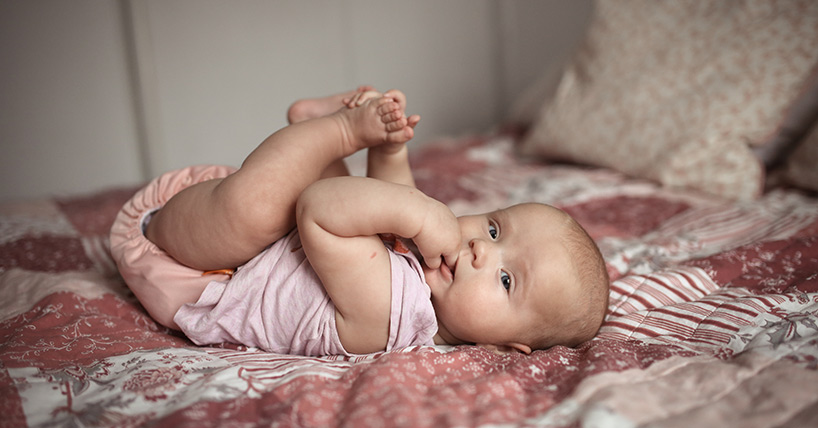 Baby lies on back
